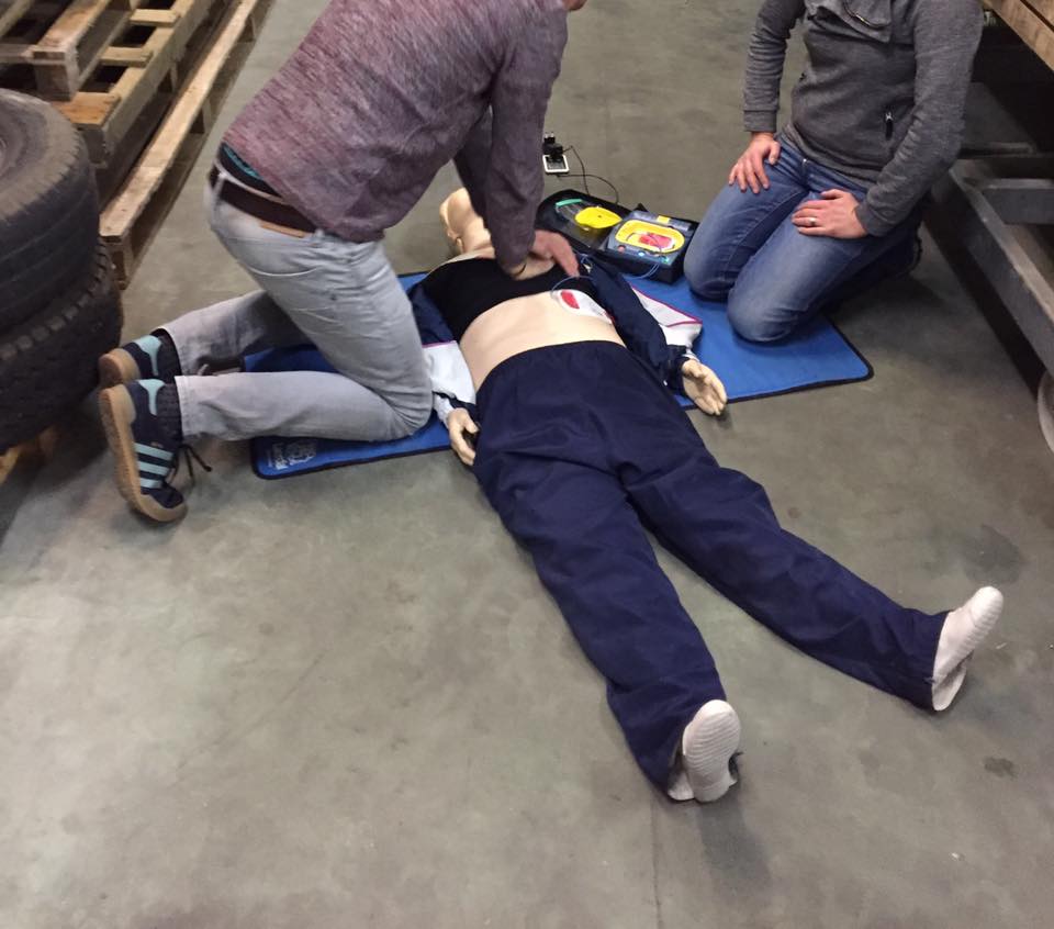 Cursisten oefenen reanimatie met AED op een oefenpop